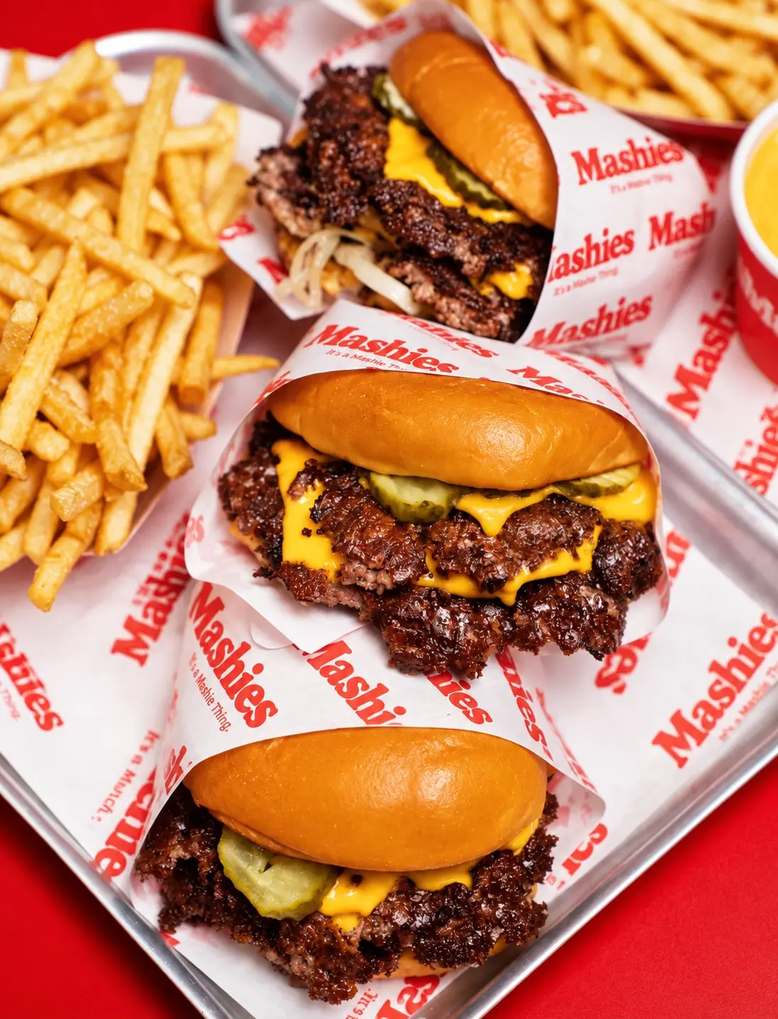 Drei Smash Burger mit Fries auf einem Tablett